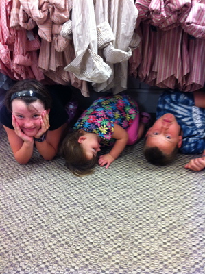Kids under the clothes racks